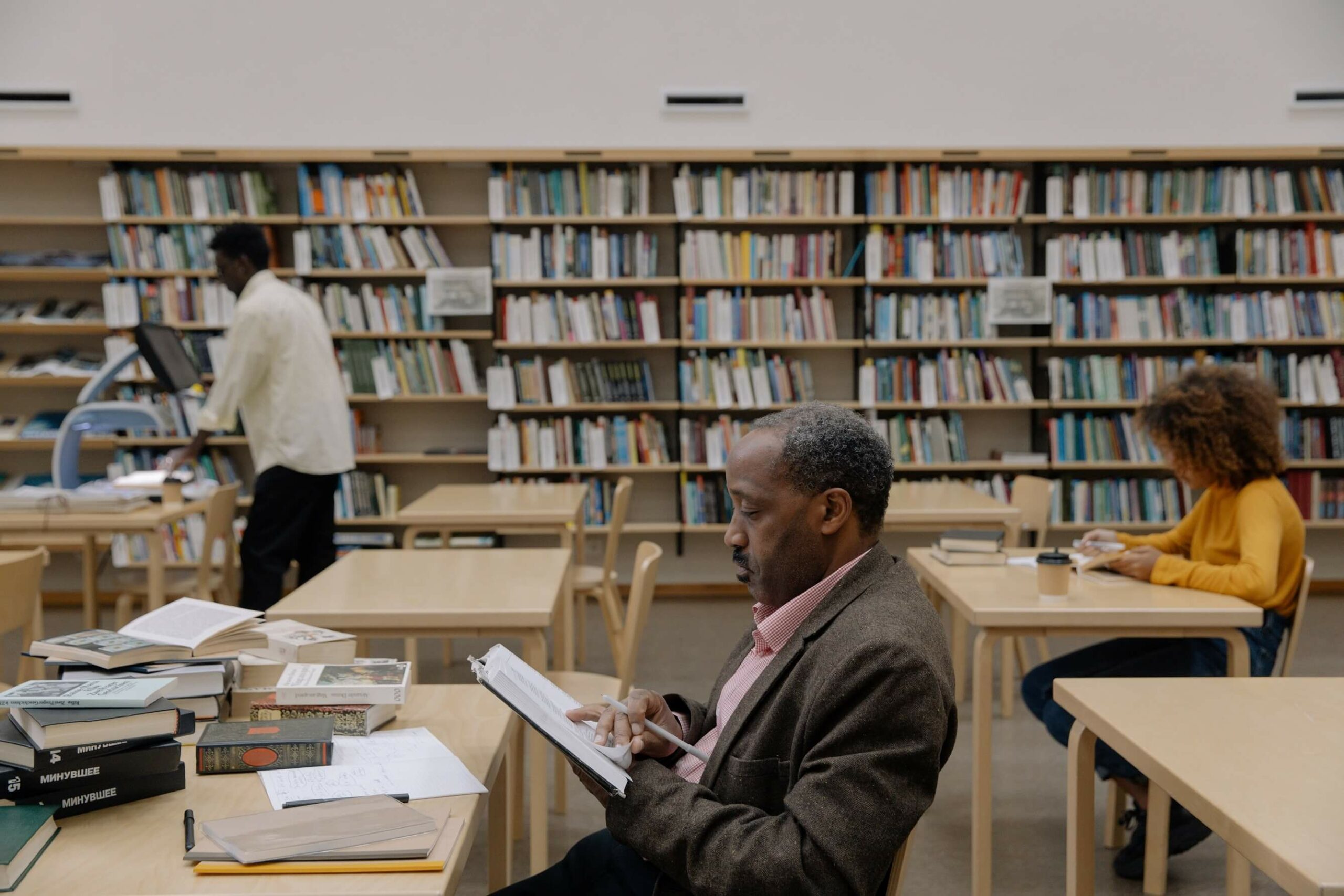 People in a library sat on different desks reading