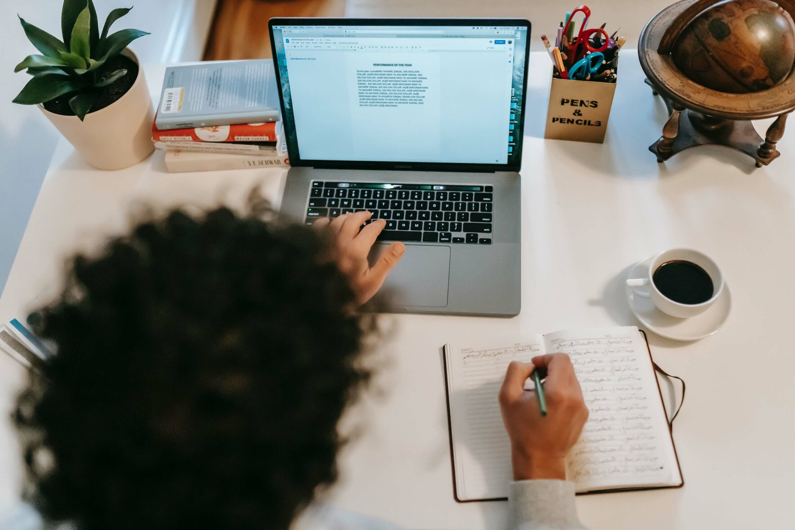 Person taking notes from computer screen