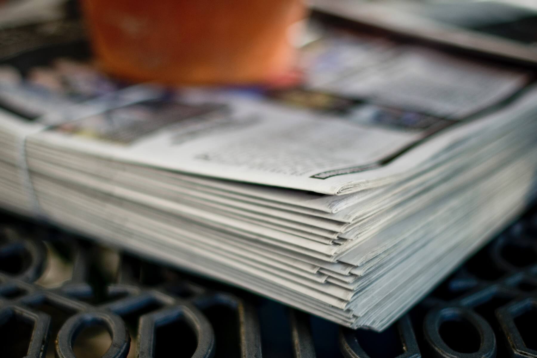 Close up of a pile of newspapers, neatly held together with a piece of string.